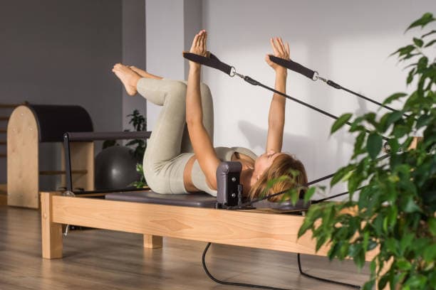 Aula de Pilates com equipamentos na clínica Focus Saúde para fortalecimento e reabilitação